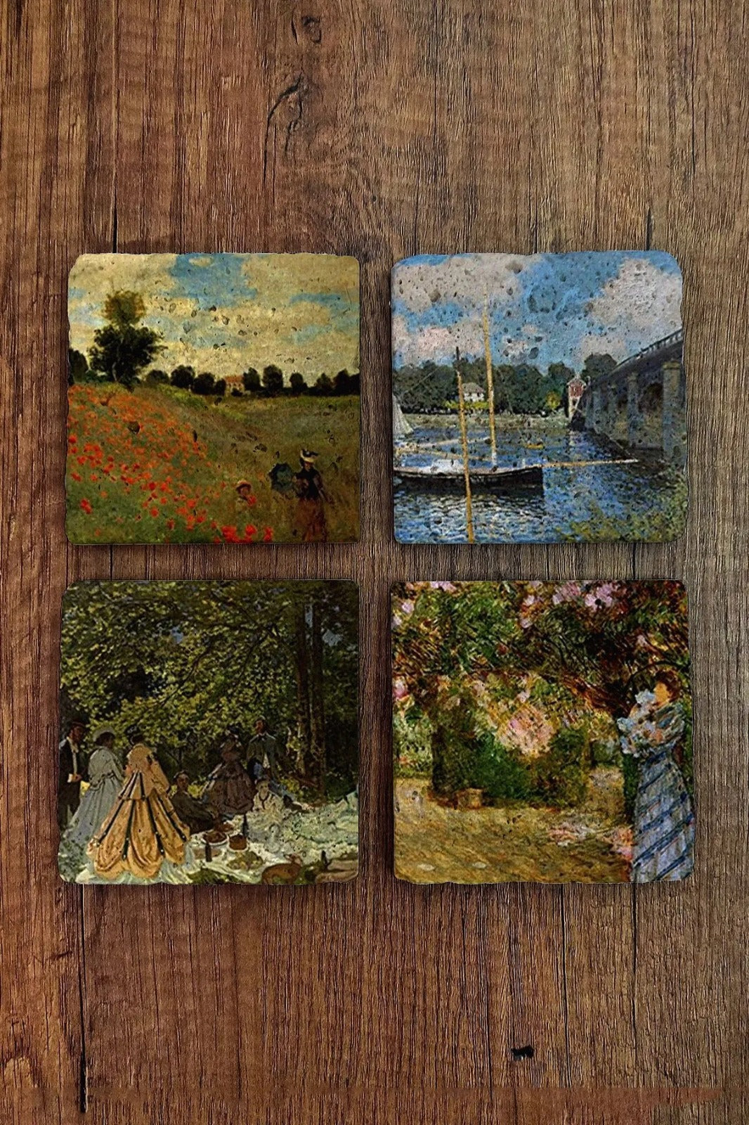 Four square artworks on a wooden surface