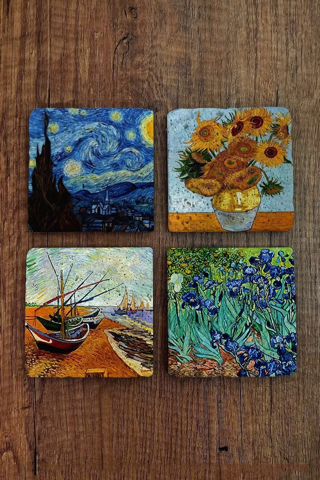 Four Van Gogh-themed coasters on a wooden surface