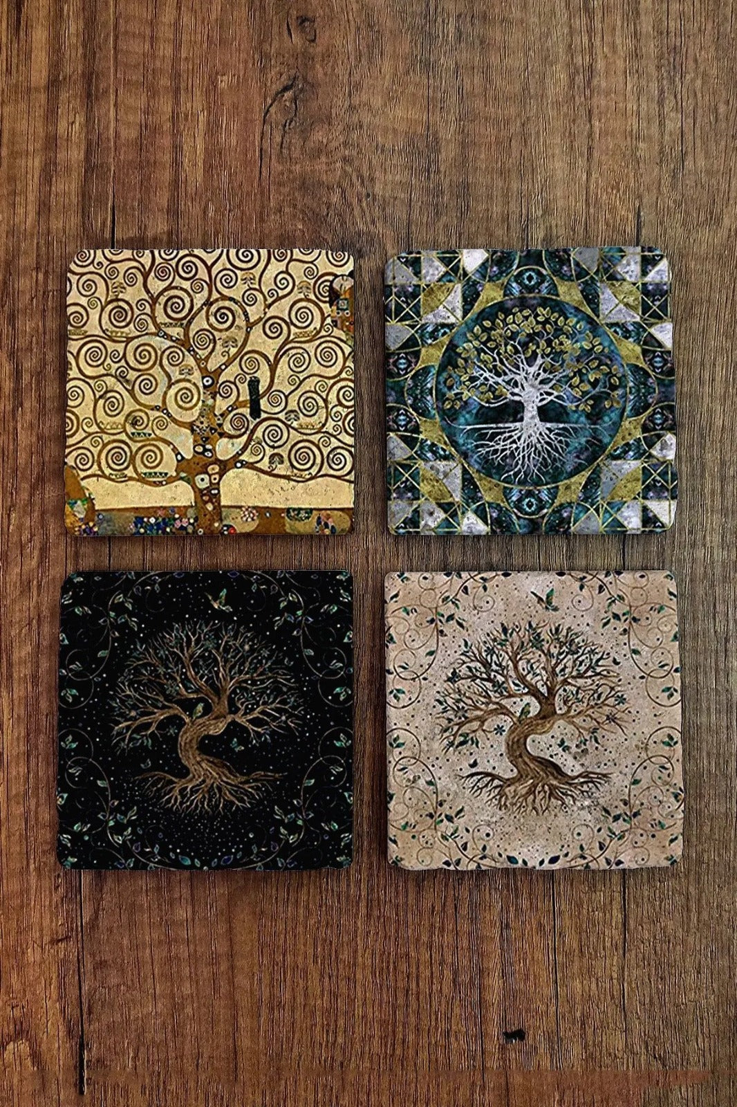Four tree-themed coasters on a wooden surface
