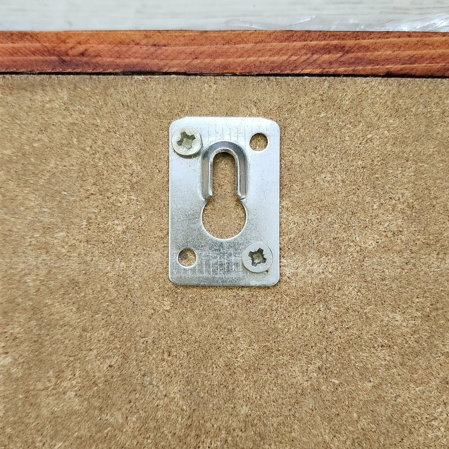 Metal escutcheon plate on a wooden surface