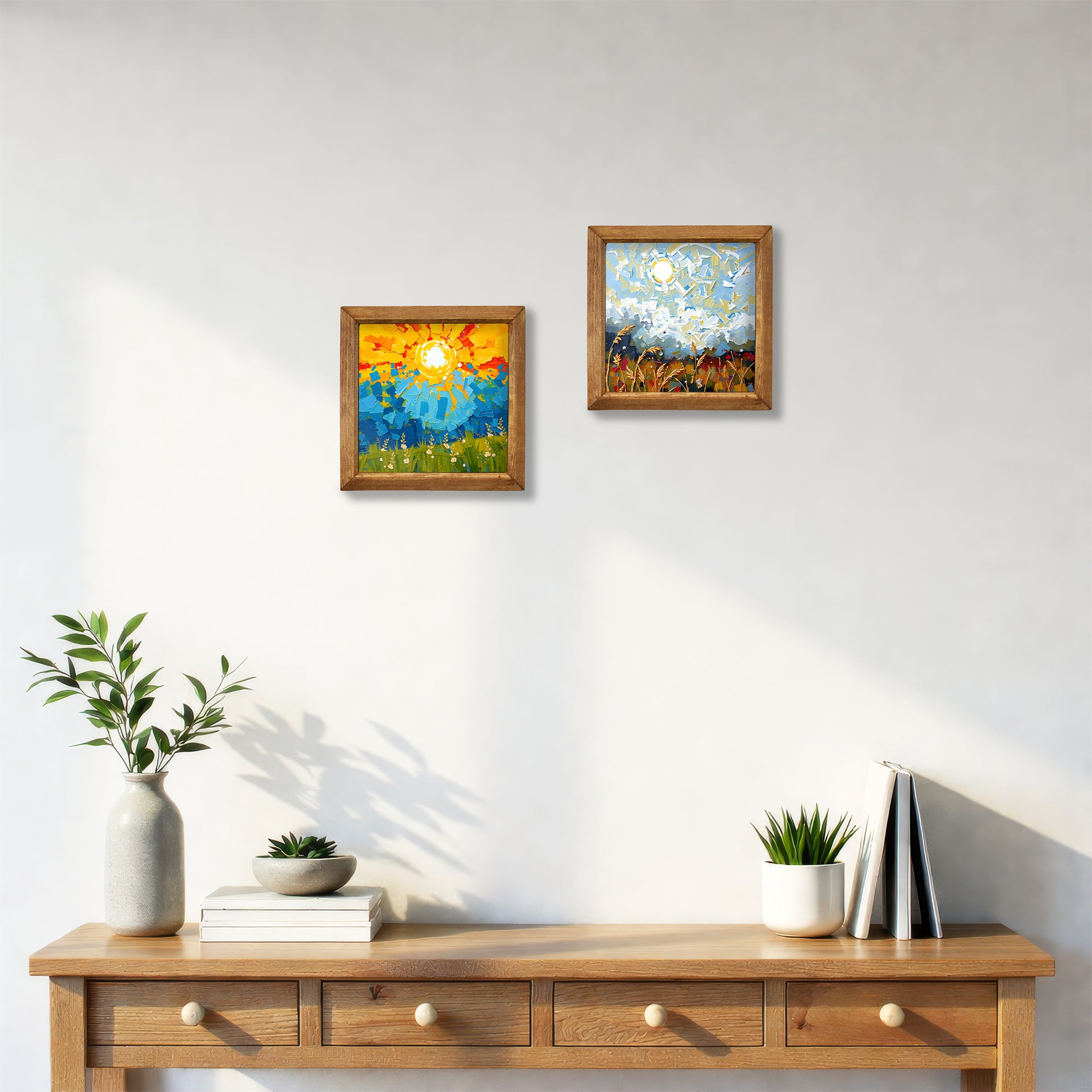 Two framed paintings on a wall above a wooden console table with decorative items.