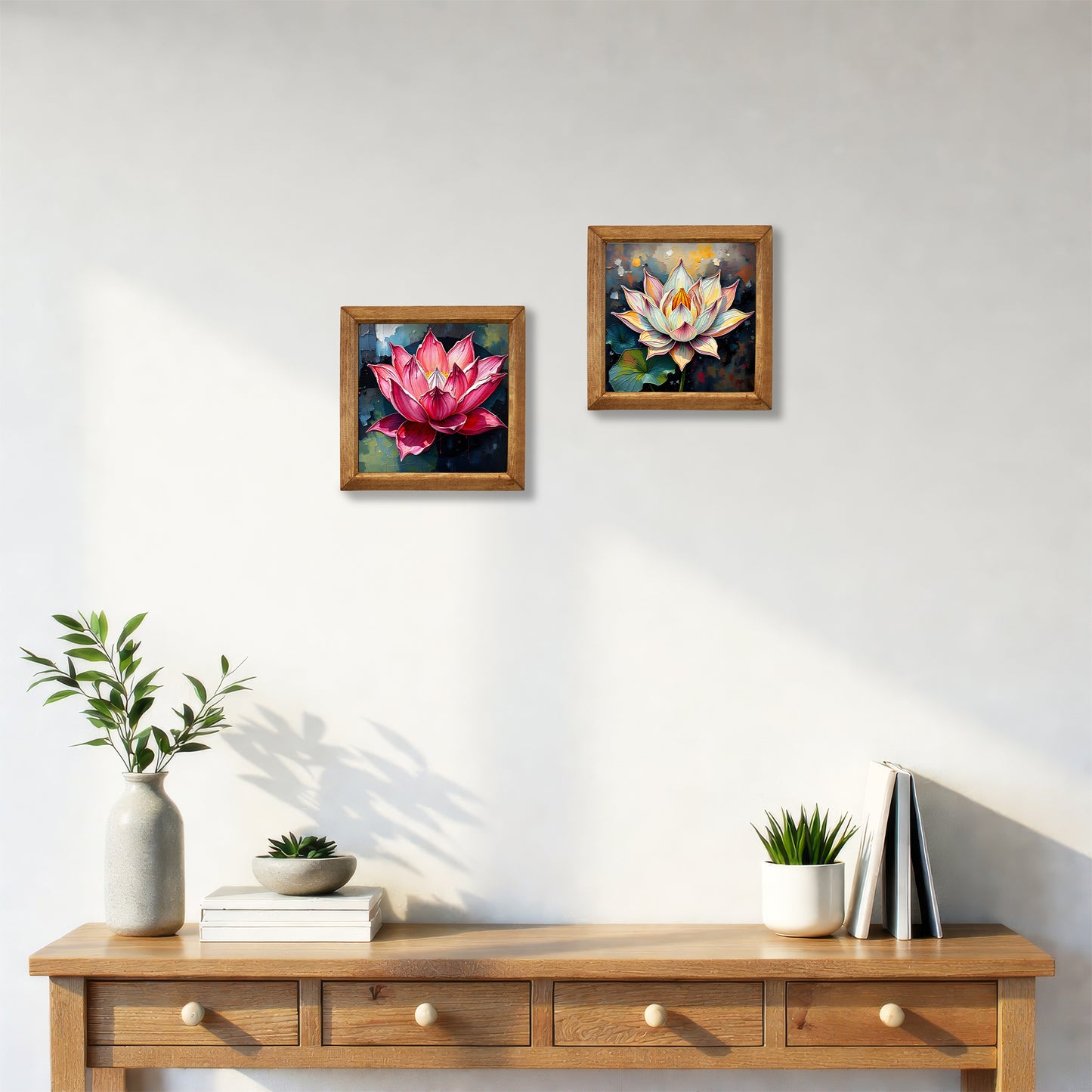 Two framed paintings of lotus flowers on a wall above a wooden console table with decor items.