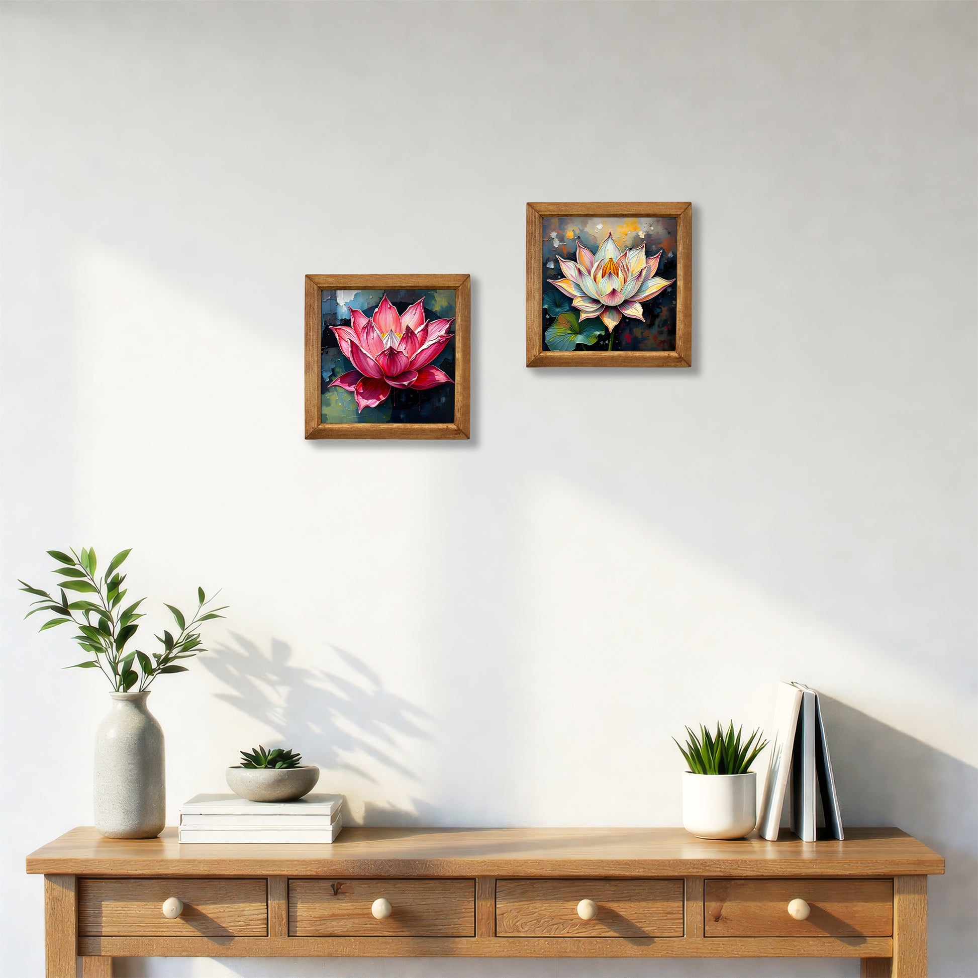 Two framed paintings of lotus flowers on a wall above a wooden console table with decor items.