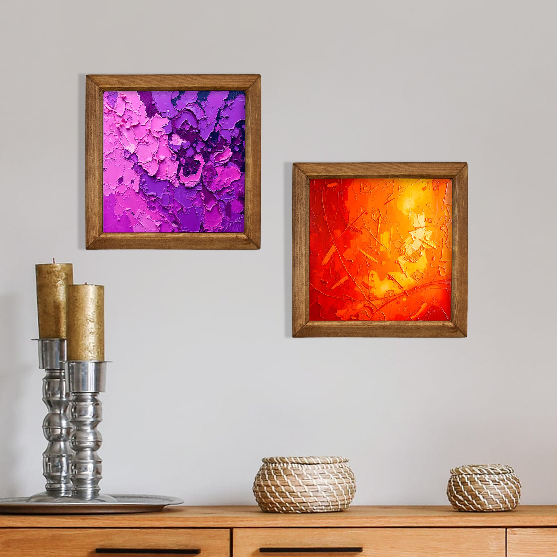 Two framed abstract artworks on a wall above a wooden cabinet with decorative items.