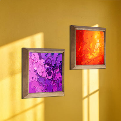 Two framed abstract artworks on a yellow wall with shadow patterns.