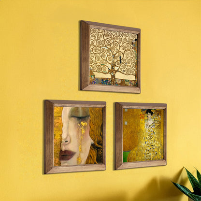Three framed artworks on a yellow wall, inspired by Gustav Klimt's style.
