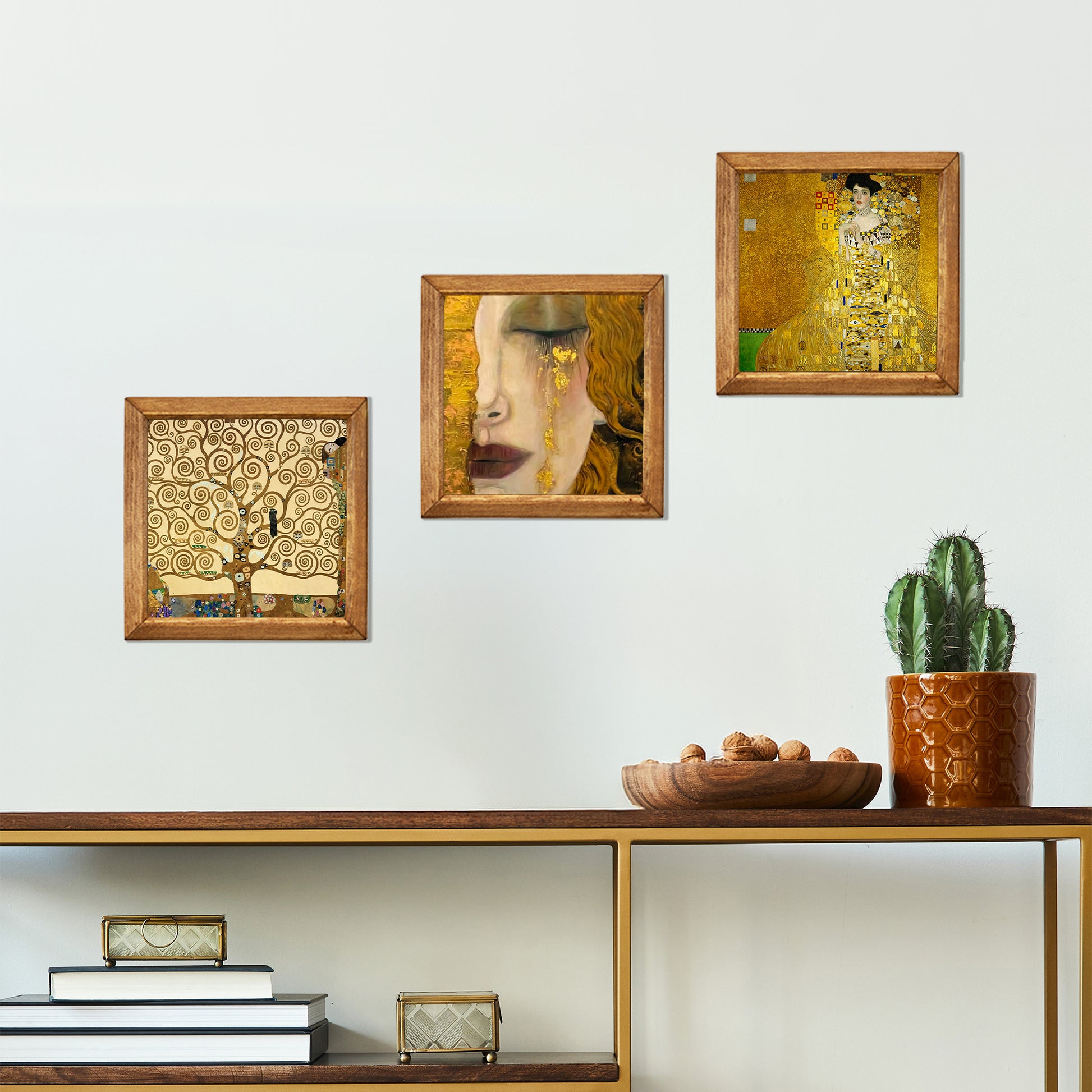 Decorative wall art pieces on a shelf with a cactus plant.