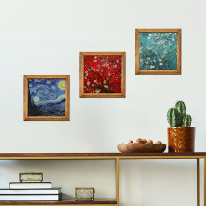 Framed artworks on a wall above a wooden shelf with decorative items.