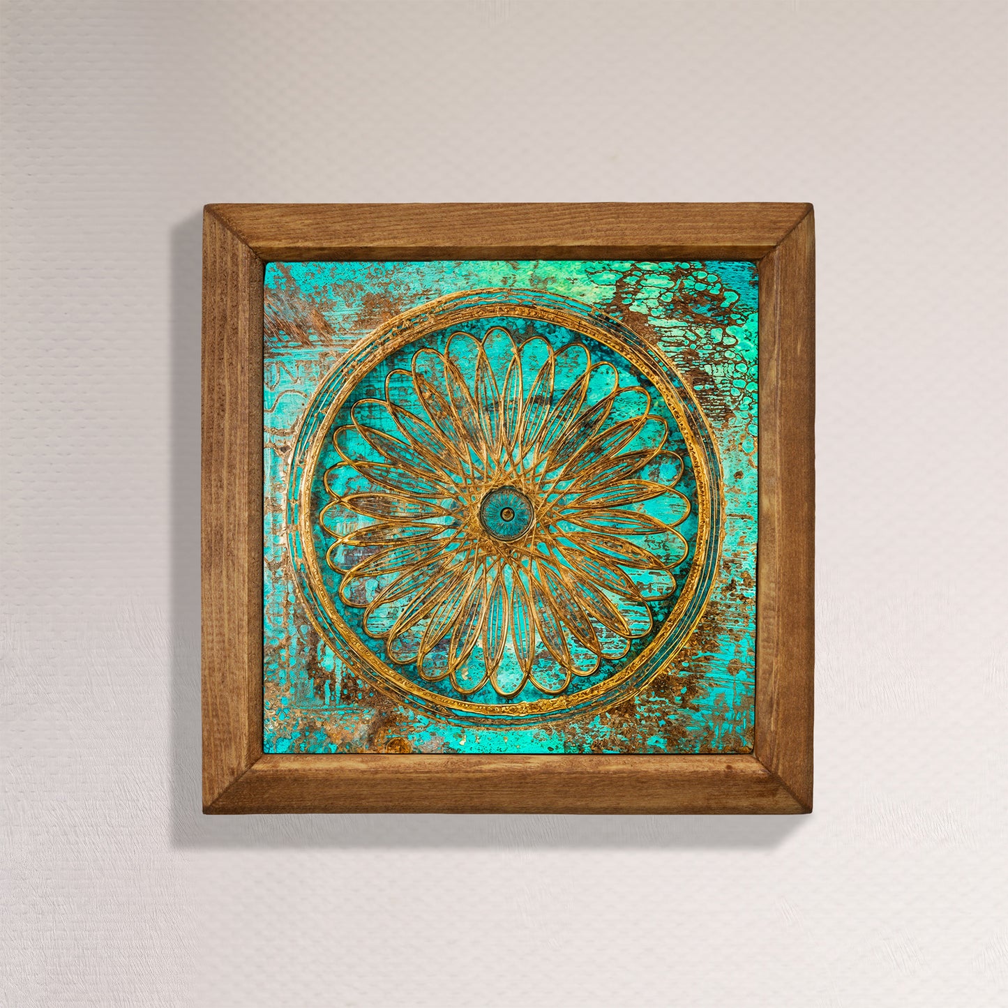 Decorative wall art with a wooden frame and teal and gold floral design on a light gray background