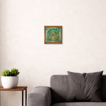 Framed artwork on a wall above a gray sofa with a plant beside it.