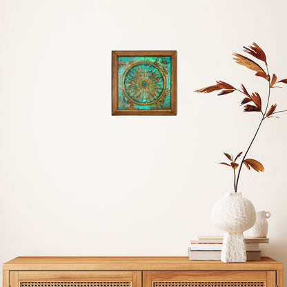 Decorative wall art piece on a white wall above a wooden console table with a vase and books.
