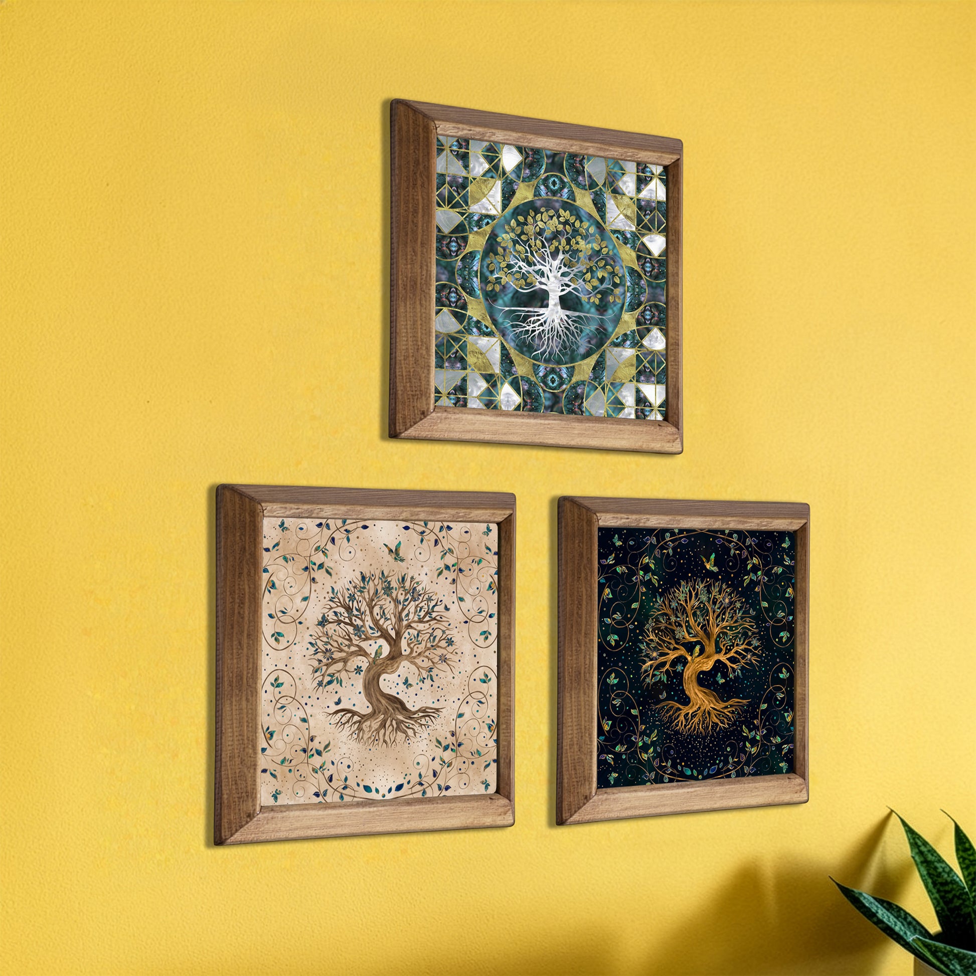 Three framed artworks of trees on a yellow wall