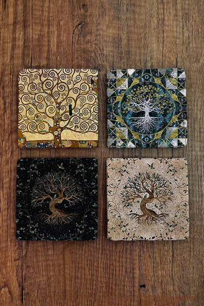 Four tree-themed coasters on a wooden surface