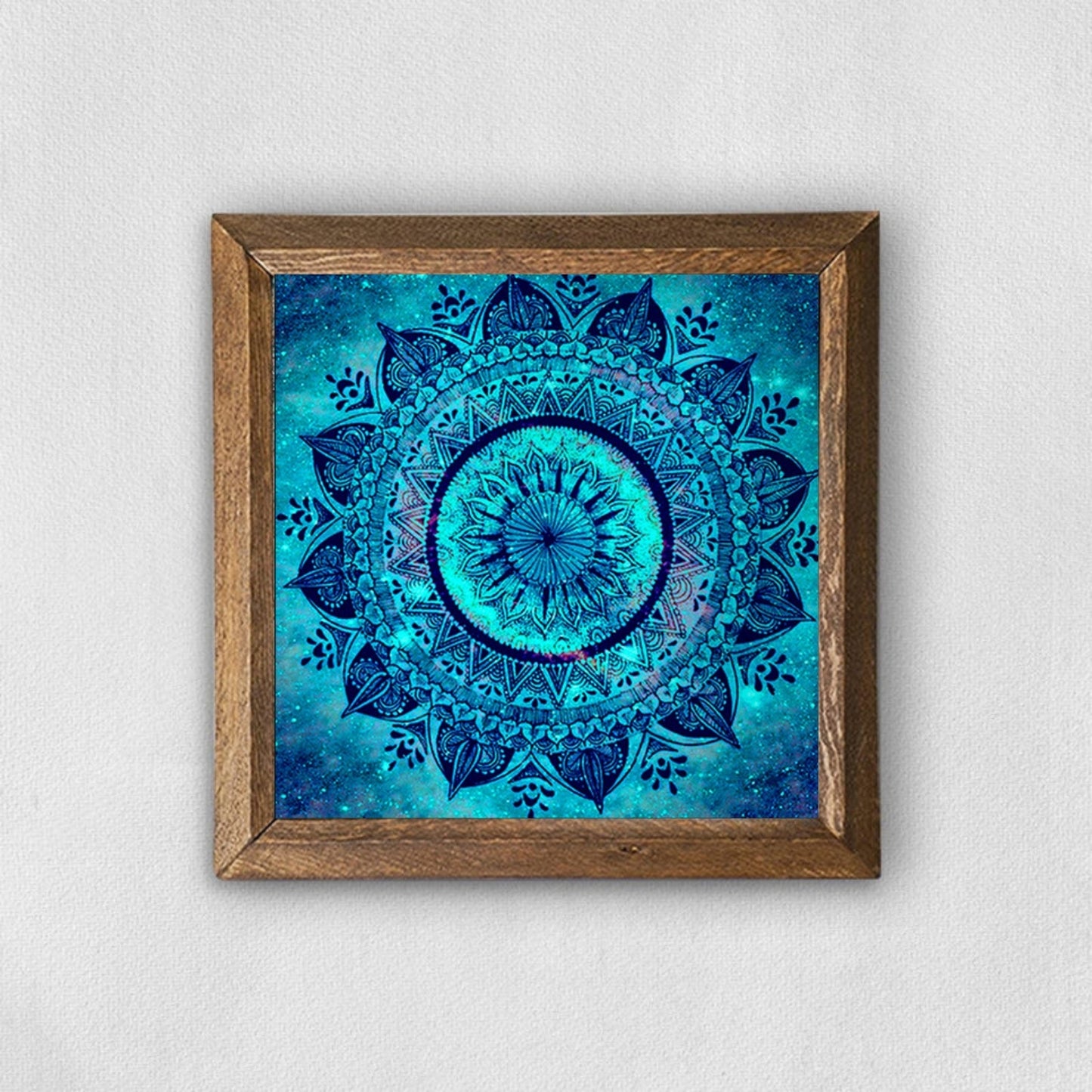 Framed blue mandala art on a white wall
