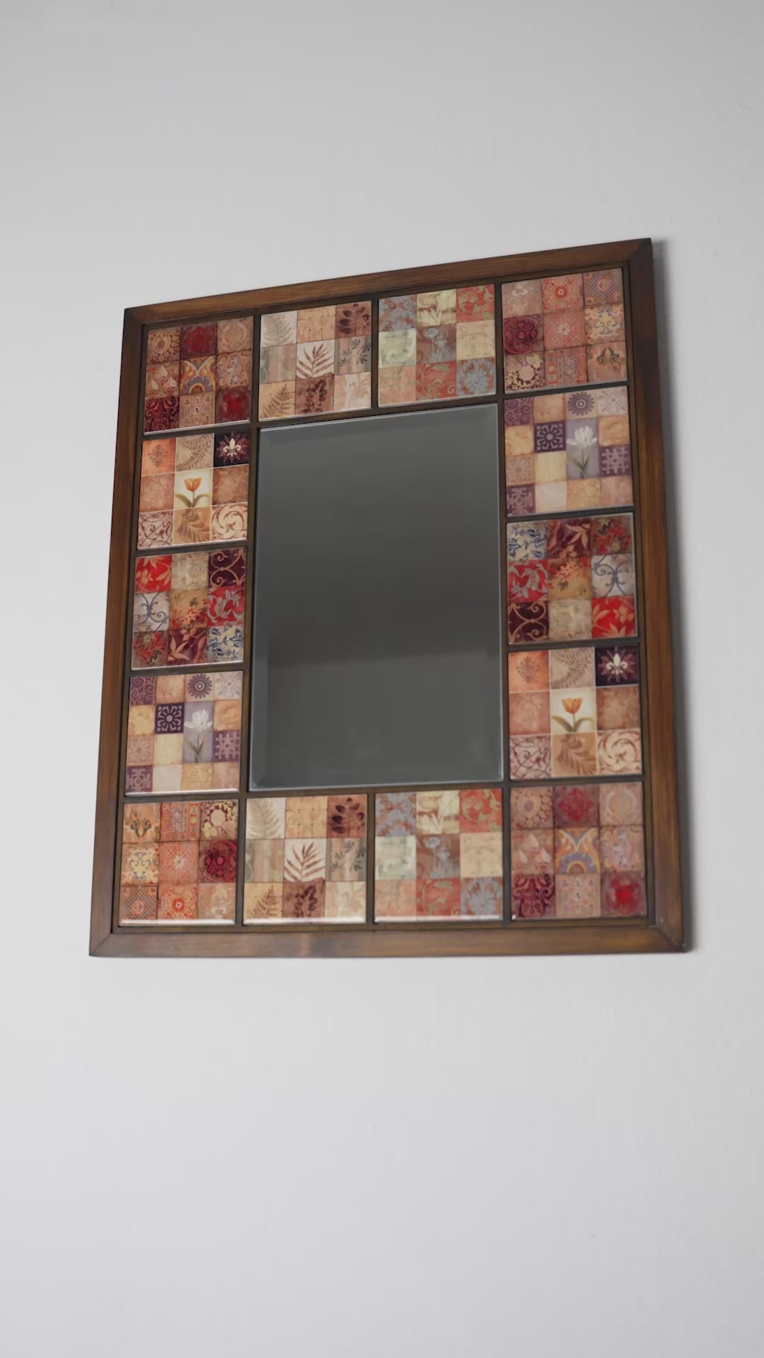 Handmade wall mirror with ceramic mosaic tiles and wooden frame, shown at an angle to highlight depth and craftsmanship, artistic home decor mirror